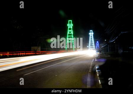 the atmosphere of the night on Tarakan City with old oil tower decorated with neon lights Stock Photo