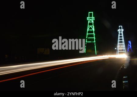 the atmosphere of the night on Tarakan City with old oil tower decorated with neon lights Stock Photo