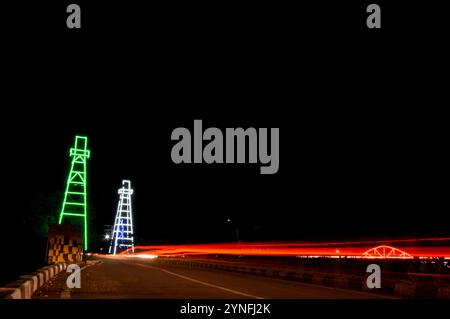 the atmosphere of the night on Tarakan City with old oil tower decorated with neon lights Stock Photo