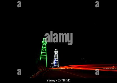 the atmosphere of the night on Tarakan City with old oil tower decorated with neon lights Stock Photo