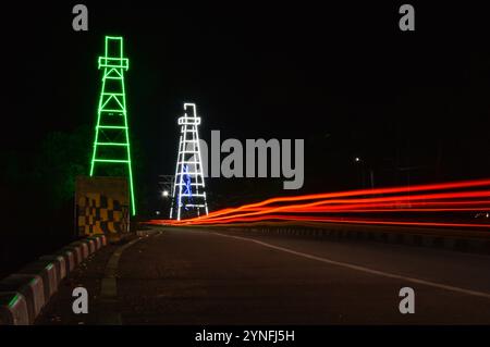 the atmosphere of the night on Tarakan City with old oil tower decorated with neon lights Stock Photo