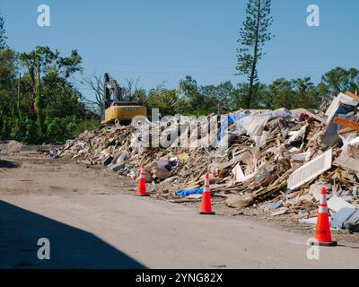 Editorial Use Only November 23, 2024. Gulfport, FL, USA. Storm Damage Debris Collection site. Inside gate with orange cone, yellow crane, and piles Stock Photo