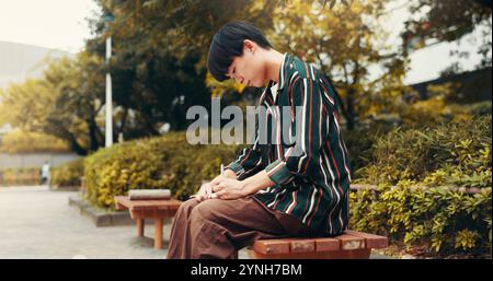 Notebook, writing and Asian man in city with ideas for university, studying and learning on campus. Journal, student and person for inspiration Stock Photo