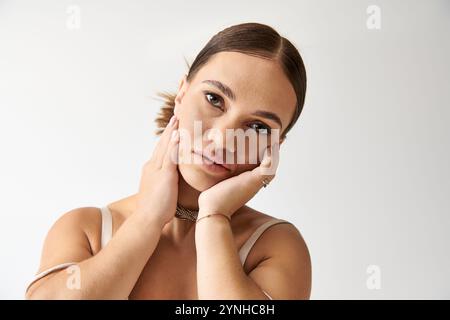 Young woman with short stature poses gracefully in a studio, radiating confidence and elegance. Stock Photo