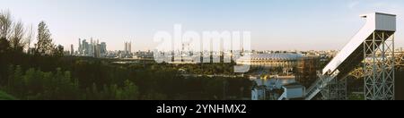 Moscow, Russia - Aug 16 2024: Panoramic view of Moscow’s cityscape during evening hours, featuring Luzhniki Stadium, Moscow City skyscrapers, and the Stock Photo