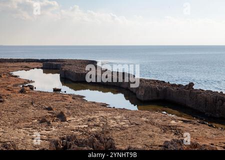 The natural pool of the Makronissos peninsula in Ayia Napa. It forms along one side of the peninsula due to waves breaking against the rocks, creating Stock Photo