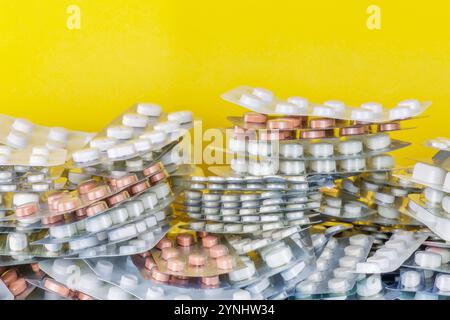 Medicine blisters with pills in front of a yellow background Stock Photo