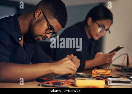 Digital, electrical engineer and people with tools, hardware and working in office, table and specialist. Update, technician and maintenance for Stock Photo