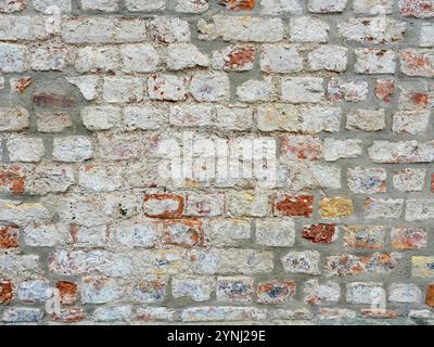 wall - brick - white - exposed - An old white medieval house wall is exposed and renovated. The masonry shows an impressive structure. Stock Photo