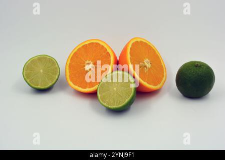 Healthy ripe delicious fruits for human health. Juicy fruits of orange orange, lime with bright green mint. Two halves of an orange, two halves. Stock Photo