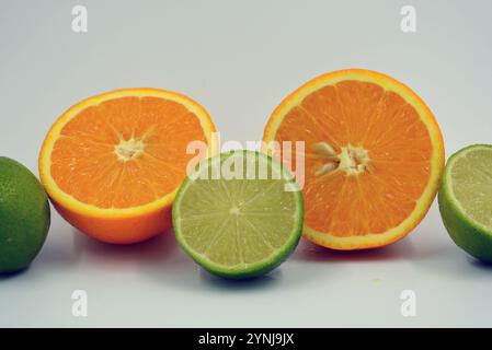 Healthy ripe delicious fruits for human health. Juicy fruits of orange orange, lime with bright green mint. Two halves of an orange, two halves. Stock Photo