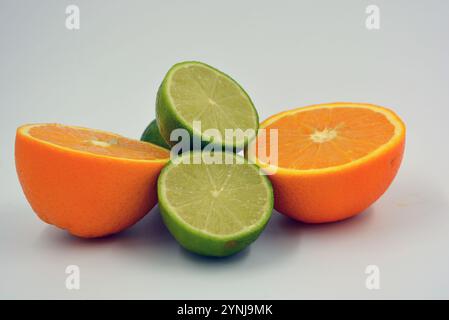 Healthy ripe delicious fruits for human health. Juicy fruits of orange orange, lime with bright green mint. Two halves of an orange, two halves. Stock Photo