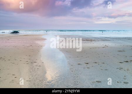 Pastel coloured sky over low tide on Gt Western Beach on the coast of Newquay in Cornwall in the UK. Stock Photo