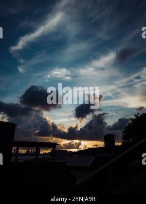 Dramatic Sunset Over Urban Silhouettes with Vibrant Clouds and Deep Blue Sky in a Captivating Evening Scene Stock Photo