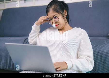 Woman working from home due to being unwell, Women working about new startup on laptop to analysis finance of project in outside office, Woman working Stock Photo