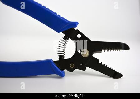 Metal plassentes with blue plastics handles for trimming wires of different diameter located on a white plastic background. Stock Photo