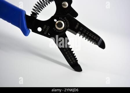 Metal plassentes with blue plastics handles for trimming wires of different diameter located on a white plastic background. Stock Photo