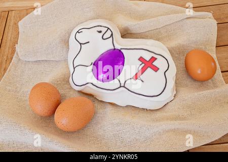 Easter lamb cake with symbolic cross and eggs on burlap cloth Stock Photo