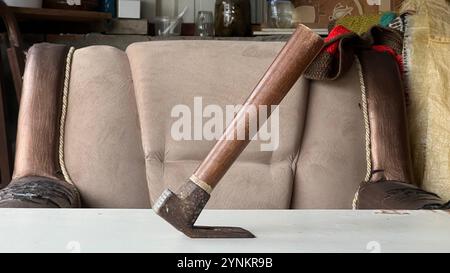 A unique wooden tool is balanced on a table in a workshop, showcasing craftsmanship. Stock Photo