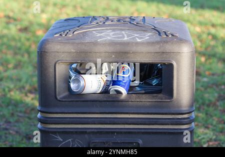 Close up of the opening of a black refuse bin with beer cans inside Stock Photo