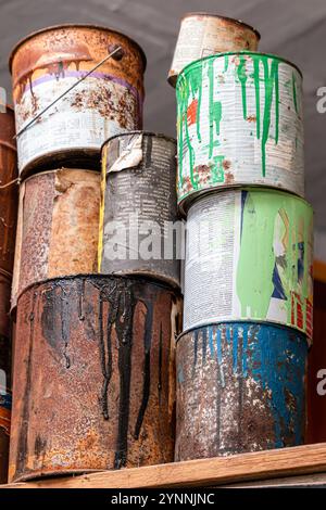 A collection of paint cans, buckets, toxic and hazardous material stacked. Hazardous waste. Stock Photo