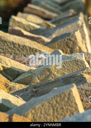 Close-up of the sandstone coping stones on the top of a dry stone wall, bathed in sunshine after a frost. Stock Photo