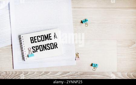 BECOME A SPONSOR the text is written on a blank sheet of notepad, on documents Stock Photo