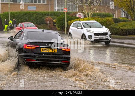 Treforest Industrial Estate, Wales, UK - 24 November 2024: Vehicles driving through floodwater from the River Taff after heavy rain from Storm Bert Stock Photo