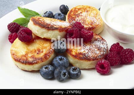 Breakfast, cottage cheese cakes, with fresh berries, and sour cream, top view, close-up, no people Stock Photo