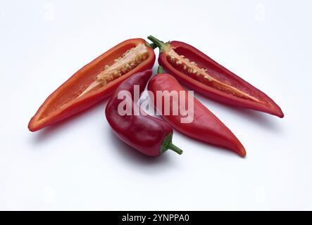 Whole and half images of various red and sweet peppers on white background. Appearance of fresh pepper seeds. Carmen sweet peppers. Stock Photo