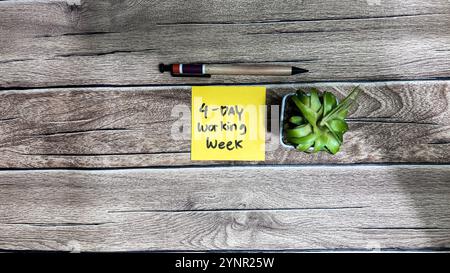 Concept of 4 day working week write on sticky notes isolated on Wooden Table. Stock Photo