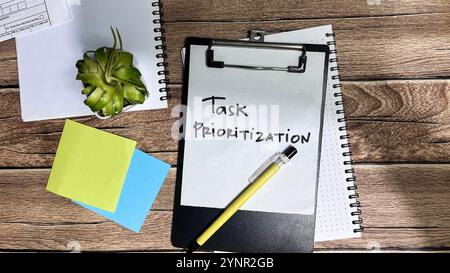 Concept of Task Prioritization write on paperwork isolated on Wooden Table. Stock Photo