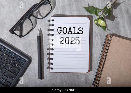New year resolutions 2025 on desk. 2025 goals list with notebook, coffee cup, plant on wooden table. Resolutions, plan, goals, action, checklist, idea Stock Photo