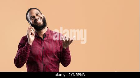 Smiling black guy talking on the phone and gesturing Stock Photo