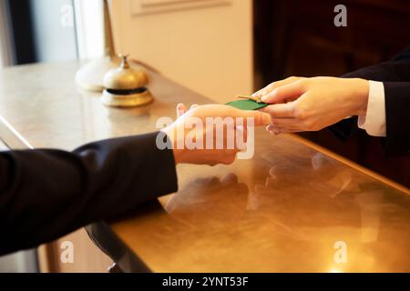 Man checking in and woman at front desk Stock Photo