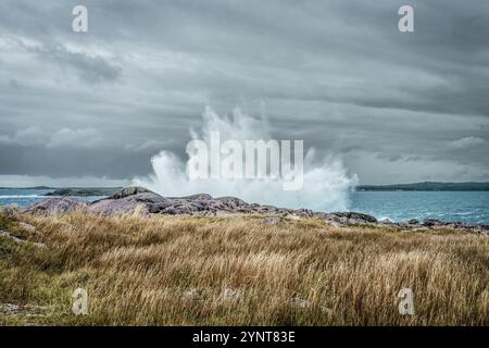 A huge wave crashes onto the rocky shore near Louisbourg Nova Scotia as a storm rolls in from the Atlantic Ocean. Stock Photo