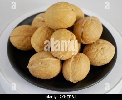 Fresh walnut on black plate with white background Stock Photo