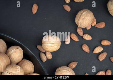 Top view of dry walnut and almonds in black plate and black background Stock Photo