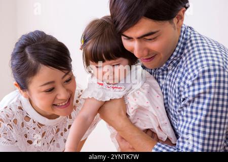 Girl being carried by family Stock Photo