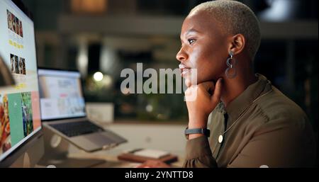 Night, black woman and thinking at computer screen for planning, web design or deadline in office. Girl, tech display or brainstorming in agency for Stock Photo
