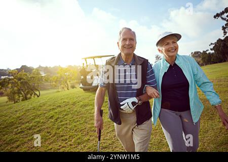 Golf, retirement and walking with old couple outdoor on course together for leisure activity. Grass, mockup space and smile with senior people playing Stock Photo