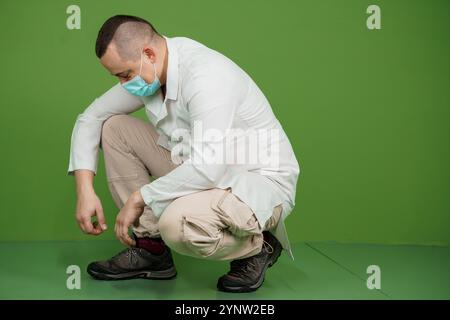 Healthcare Professional in Protective Gear Preparing for a Task in a Studio Environment. Stock Photo