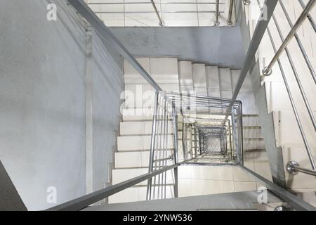 Generic modern square staircase shaft with steel net for fall safety Stock Photo