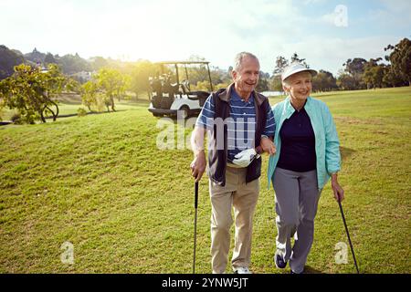 Golf, retirement and walking with senior couple outdoor on course together for leisure activity. Grass, hobby and mockup space with old people playing Stock Photo