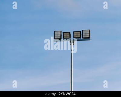 LED floodlights mounted on a high pole against a blue sky. Copy space Stock Photo