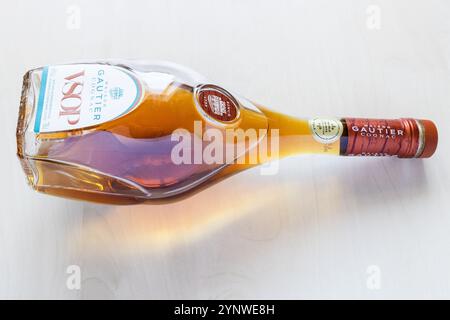 Moscow, Russia - October 1, 2024: glass bottle of Cognac VSOP Maison Gautier lies on light brown wooden board Stock Photo