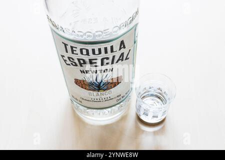 Moscow, Russia - October 1, 2024: shot and glass bottle of Tequila Especial Newton Blanco on light brown wooden board Stock Photo