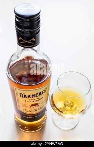 Moscow, Russia - October 1, 2024: wineglass and standing glass bottle of Bacardi OakHeart Rum on light brown wooden board Stock Photo