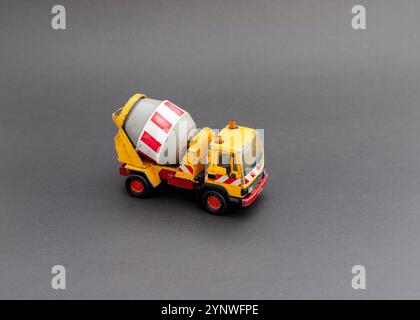 Yellow cement mixer toy truck on grey background Stock Photo