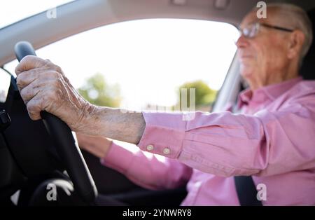 Senior Man Driving Car With Close Up Of Hands On Steering Wheel Stock Photo